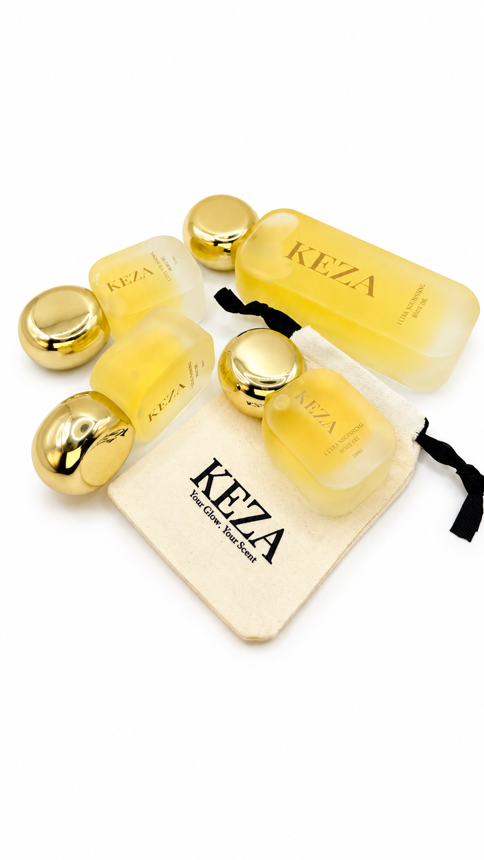 Keza body care set featuring translucent yellow bottles, shiny gold spherical containers, a cream-colored drawstring pouch with the Keza logo, and a small black ribbon, all arranged on a plain white background.