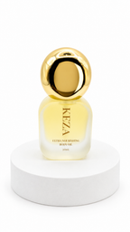 A small bottle of KEZA Ultra Nourishing Body Oil with a reflective gold cap and pale yellow liquid, displayed on a white cylindrical pedestal against a white background.