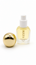 KEZA mini Ultra Nourishing Body Oil in a frosted glass bottle with a white spray cap, shown next to its reflective gold spherical cap on a white background.